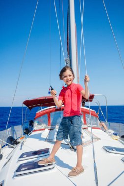 Küçük çocuk yaz gezisinde yelkenli yatında. Seyahat macerası, çocuğuyla yat gezisi..