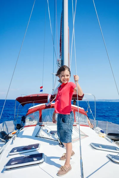 Niño a bordo de un yate de vela en un crucero de verano. Aventura de viaje, yates con niños en vacaciones en familia. — Foto de Stock