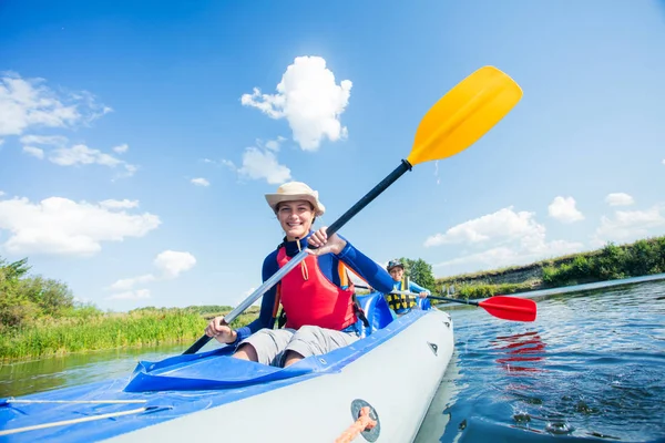 Mutlu kız yaz tatilinde güneşli bir günde nehirde kano yapıyor.
