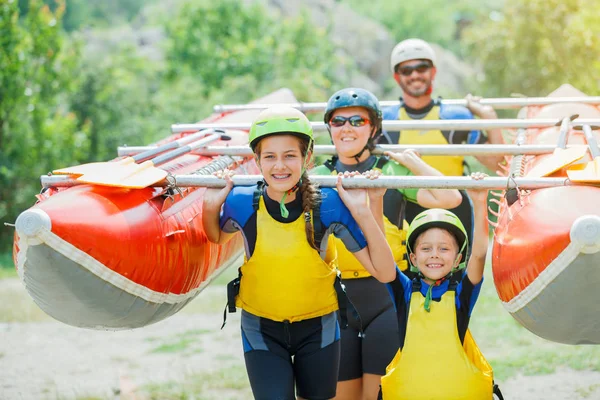 Felice famiglia di quattro in casco e gilet dal vivo pronto per il rafting sul catamarano — Foto Stock