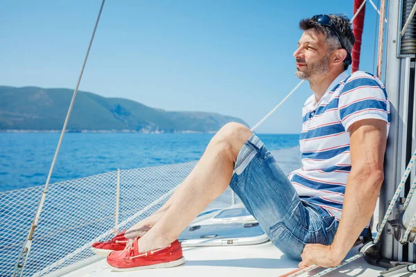 Young man on sailing yacht Stock Photo