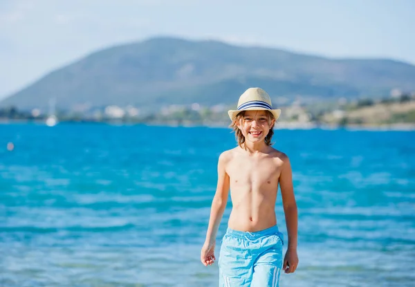 Niño caminando en la hermosa playa junto al agua — Foto de Stock