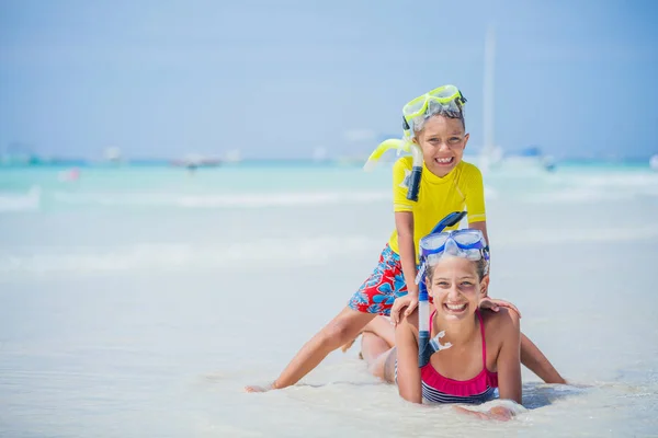 Hermano y hermana en máscaras de buceo jugando en la playa durante el caluroso día de vacaciones de verano . — Foto de Stock
