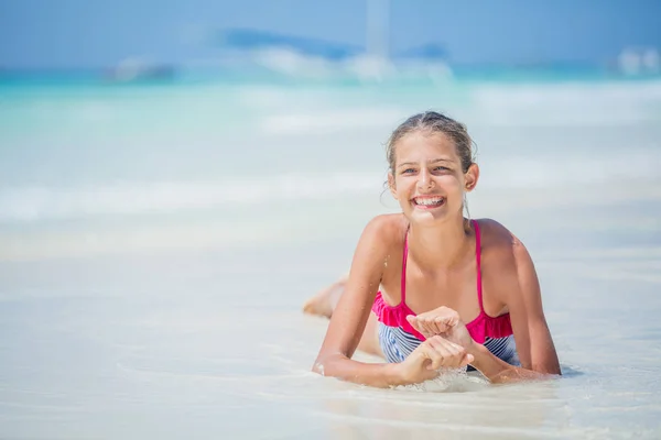 Chica en bikini acostada y divirtiéndose en la playa tropical — Foto de Stock