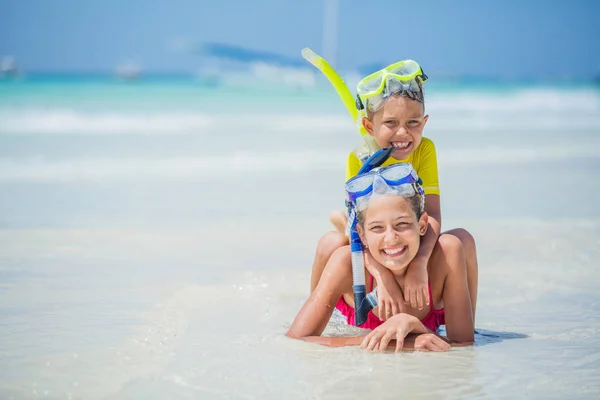在炎热的夏日假期里, 在沙滩上玩潜水面具的兄弟姐妹. — 图库照片