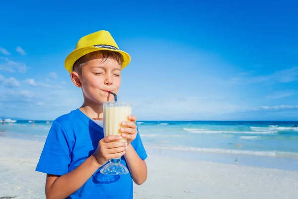 Маленький хлопчик п'є сік на тропічному літньому пляжі — стокове фото