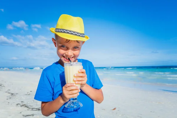Kleiner Junge trinkt Saft am tropischen Sommerstrand — Stockfoto