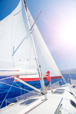 Küçük çocuk yaz gezisinde yelkenli yatında. Seyahat macerası, çocuğuyla yat gezisi..