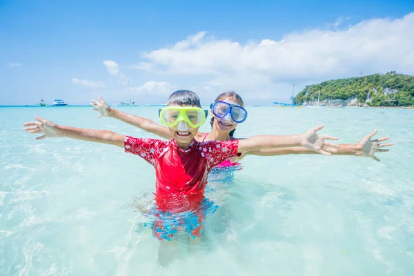 Twee gelukkige jonge geitjes in duiken maskers plezier op het strand — Stockfoto