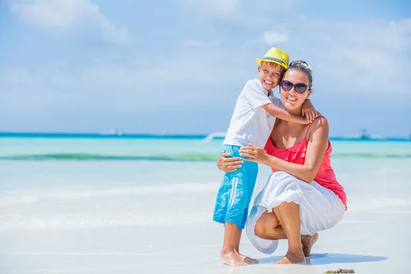 Счастливая семья отдыхает на пляже летом. Мать с мальчиком отдыхают на пляже. Молодая мать и ее очаровательный маленький сын на пляже каникулы — стоковое фото