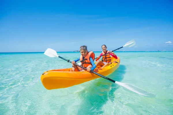 Feliz niño y niña kayak en el mar tropical en kayak amarillo — Foto de Stock