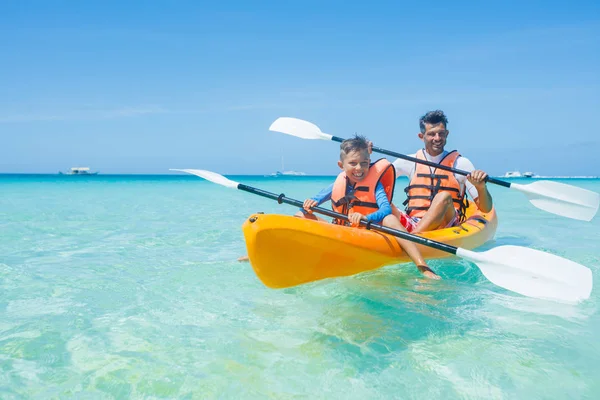 Felice ragazzo e suo padre kayak al mare tropicale su kayak giallo — Foto Stock