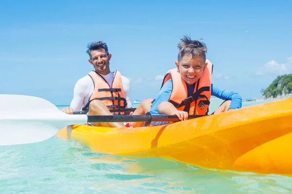 幸せな少年と彼の父親は、黄色いカヤックの熱帯の海でカヤック — ストック写真