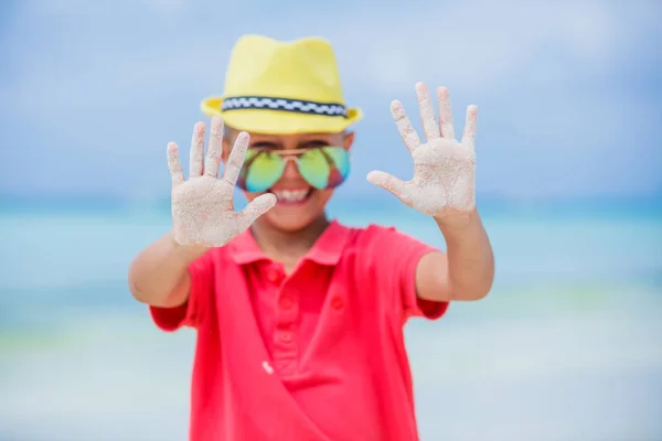 Щаслива дитина в жовтому капелюсі і сонцезахисних окулярах на пляжі. Концепція літніх канікул — стокове фото