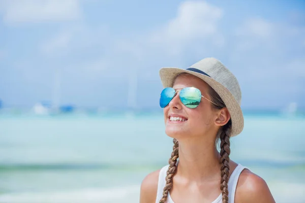 Glückliches Mädchen mit Hut und Sonnenbrille am Strand. Sommerferienkonzept — Stockfoto