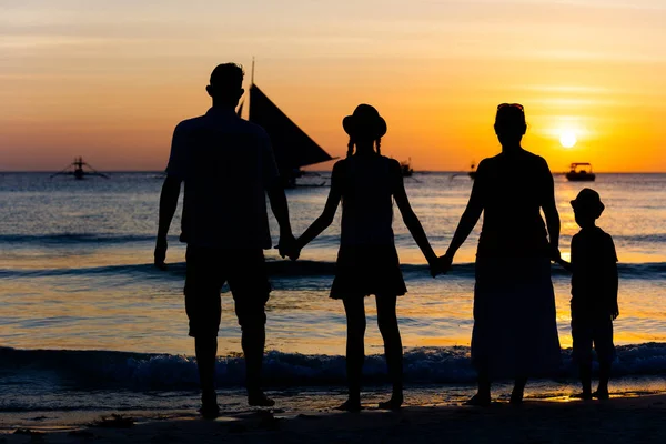 Silhouette of happy family having fun on the beach at the sunset time. — Stock Photo, Image