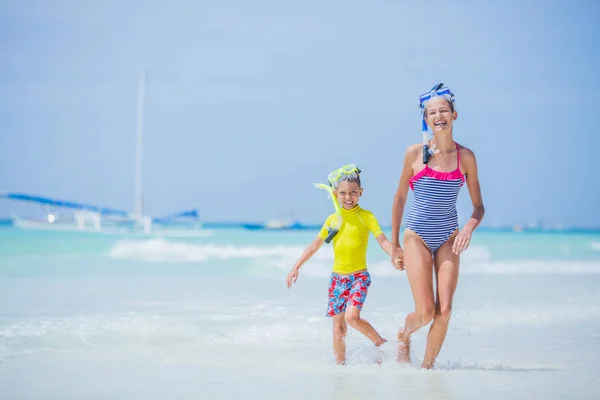 Hermano y hermana corriendo en la playa durante el caluroso día de vacaciones de verano . — Foto de Stock