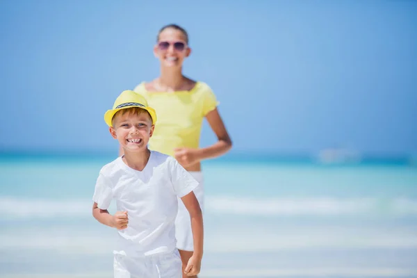 Hermano y hermana corriendo en la playa durante el caluroso día de vacaciones de verano . — Foto de Stock