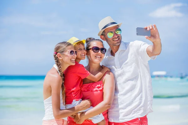 Семья из четырех человек веселится на пляже — стоковое фото
