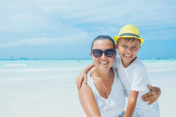 Happy family resting at beach in summer. Mother with boy resting on the beach. Young mother and her adorable little son on beach vacation — Stock Photo, Image