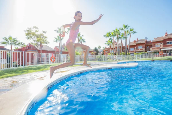 Счастливая девушка прыгает в бассейне — стоковое фото