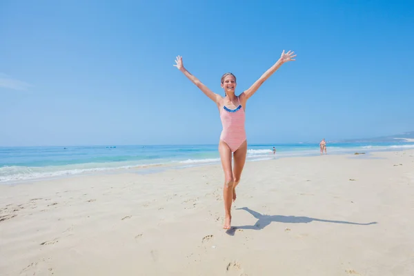 Chica en traje de baño corriendo y divirtiéndose en la playa tropical —  Fotos de Stock
