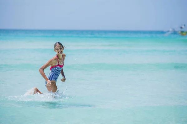 Menina de maiô executando e se divertindo na praia tropical — Fotografia de Stock