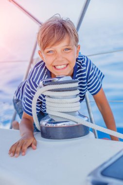 Küçük çocuk yaz gezisinde yelkenli yatında. Seyahat macerası, çocuğuyla yat gezisi..