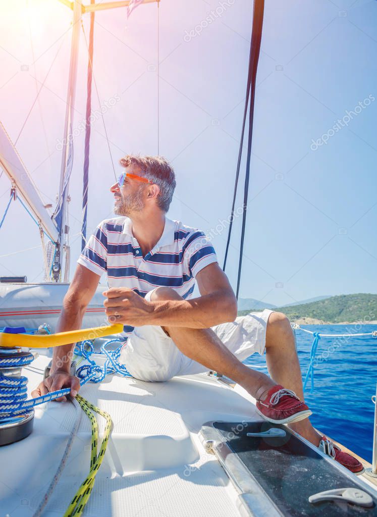 Young man sailing yacht