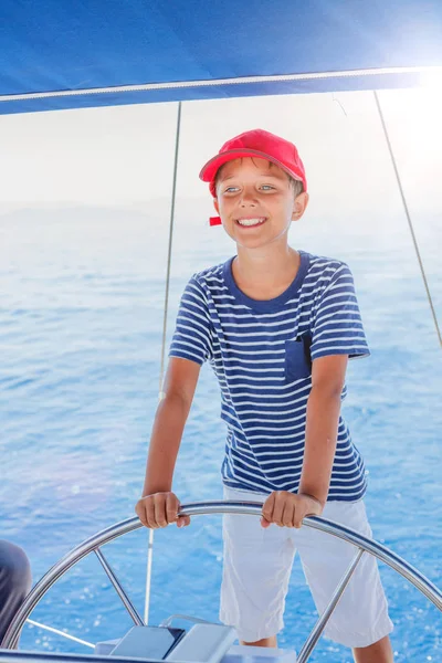 Niño a bordo de un yate de vela en un crucero de verano. Aventura de viaje, yates con niños en vacaciones en familia. — Foto de Stock