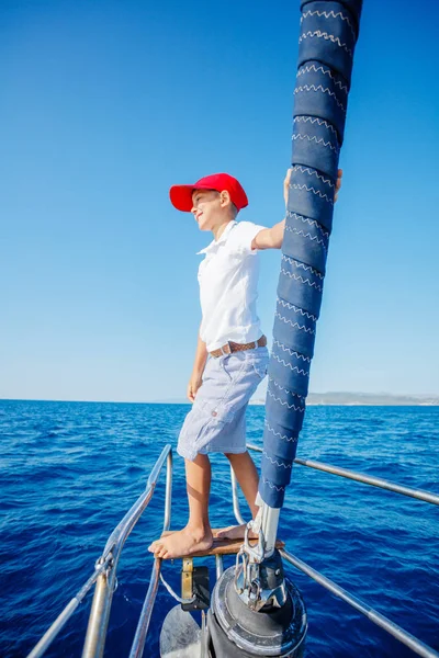 Niño a bordo de un yate de vela en un crucero de verano. Aventura de viaje, yates con niños en vacaciones en familia. — Foto de Stock