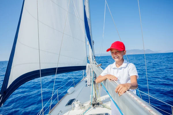 Niño a bordo de un yate de vela en un crucero de verano. Aventura de viaje, yates con niños en vacaciones en familia. — Foto de Stock