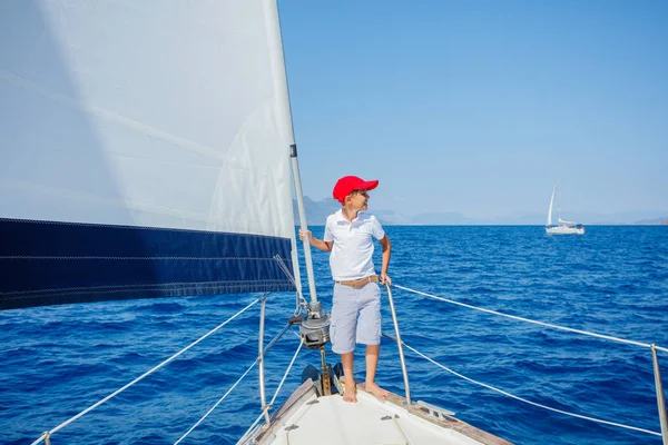 Egy kisfiú a vitorlás jachton a nyári hajóúton. Utazás kaland, jachtozás gyermekkel családi nyaralás. — Stock Fotó