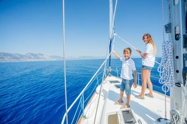 Niño con su hermana a bordo de yate de vela en crucero de verano. — Foto de Stock