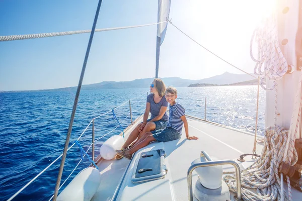 Ragazzo con la madre a bordo di yacht a vela in crociera estiva . — Foto Stock