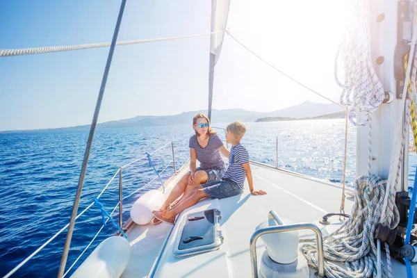 Jongen met zijn moeder aan boord van een zeiljacht op summer cruise. — Stockfoto
