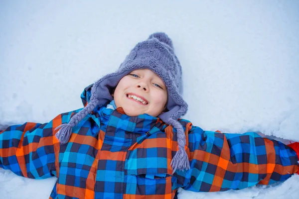 Красивий молодий хлопчик розважається в зимовому парку — стокове фото