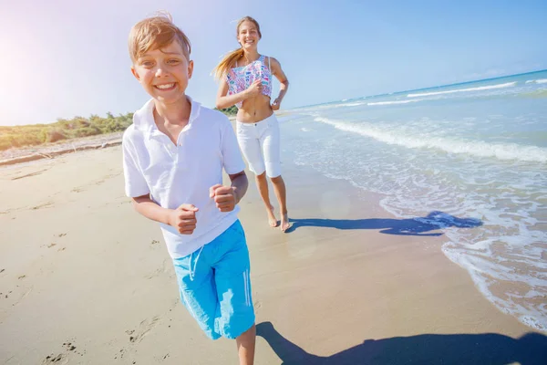 Adorável menino com sua irmã se divertir na praia . — Fotografia de Stock