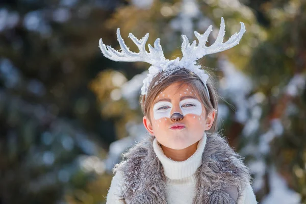 Porträtt av leende pojke med roliga horn av en hjort. Holiday koncept. — Stockfoto