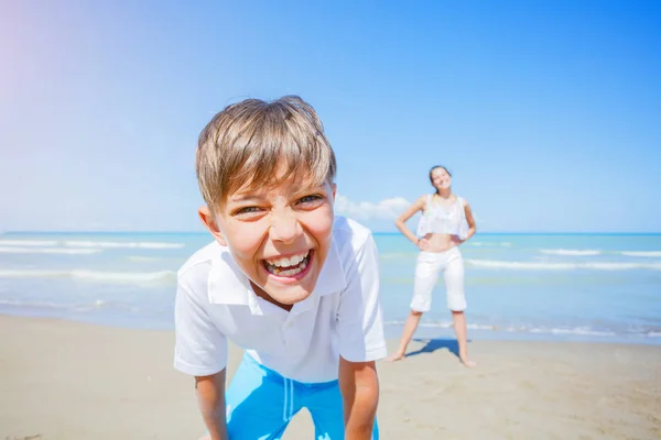 Adorável menino com sua irmã se divertir na praia . — Fotografia de Stock