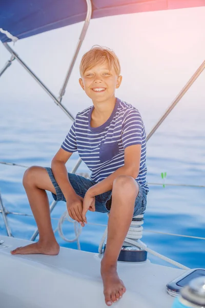 Ragazzino a bordo di yacht a vela in crociera estiva. Avventura di viaggio, yachting con bambino in vacanza in famiglia. — Foto Stock