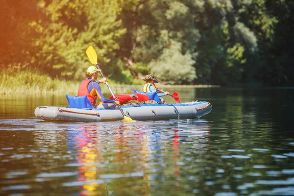 Happy kids kayaking on the river on a sunny day during summer vacation — Stock Photo, Image