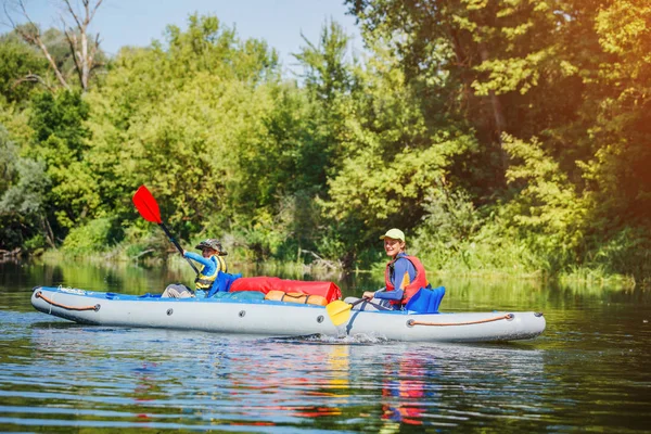 Niños felices haciendo kayak en el río en un día soleado durante las vacaciones de verano —  Fotos de Stock
