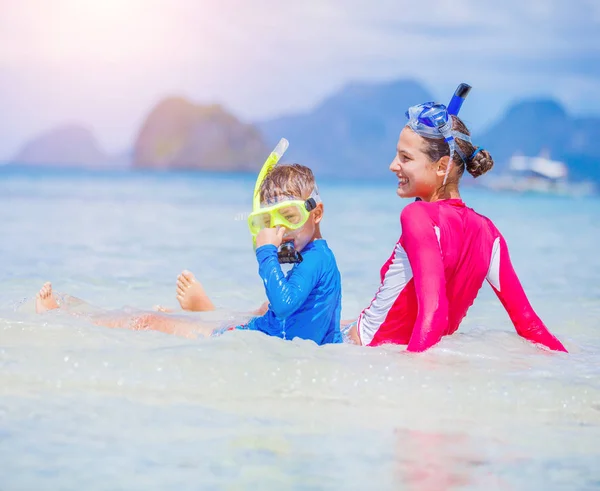 Linda chica y niño nadando en la playa tropical — Foto de Stock