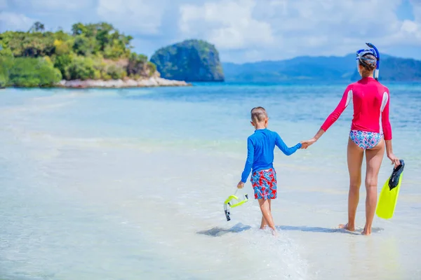Вид сзади симпатичной девочки и мальчика, прогуливающихся по пляжу — стоковое фото