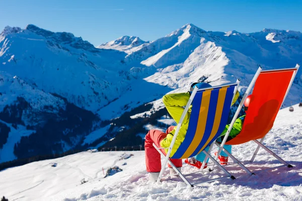 Skifahrer und Snowboarder ruhen in langen Stühlen — Stockfoto