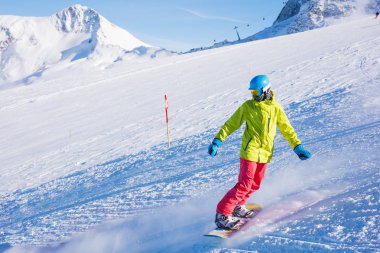 Kız snowboardcu kış kayak merkezinde eğleniyor..