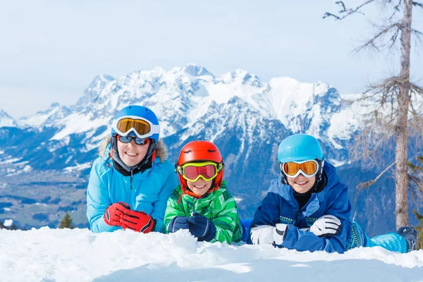 幸せな家族は山で冬の休暇を楽しんでいます。スキー、太陽、雪と楽しみ. — ストック写真