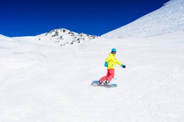 Kız snowboardcu kış kayak merkezinde eğleniyor..