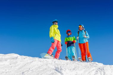 Mutlu aile dağlarda kış tatilinin tadını çıkarıyor. Kayak, güneş, kar ve eğlence.